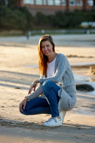 Mother smiling at beach on sunset - Australian Stock Image
