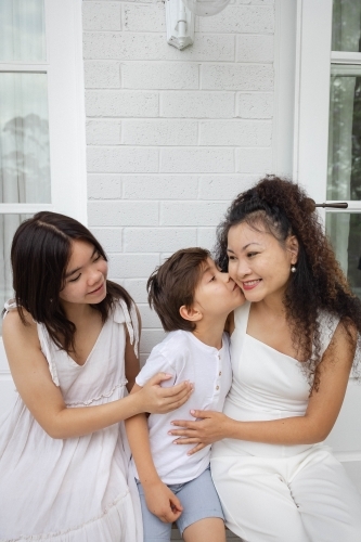 Mother, son and daughter wearing white sitting together - Australian Stock Image
