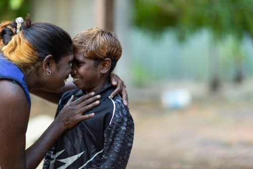 mother squashing her face up close to her son with blurred background - Australian Stock Image