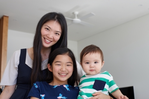 Mother with daughter and baby boy at home - Australian Stock Image