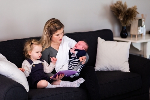 mother with two children baby and toddler reading books