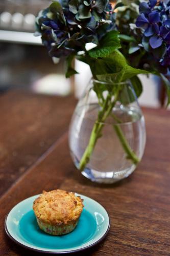 Muffin on an aquamarine plate with a vase of hydrangeas
