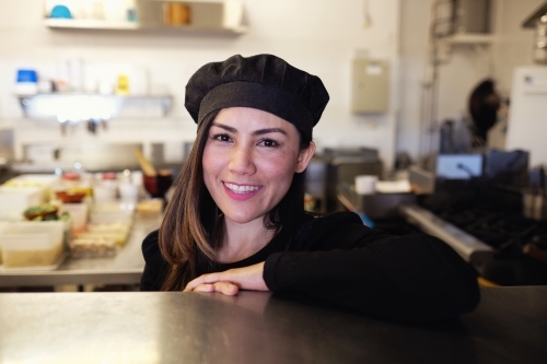 Multicultural Asian chef in Thai small business restaurant - Australian Stock Image