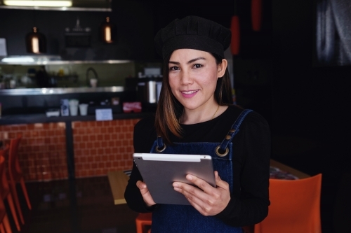Multicultural Asian waitress taking order at Thai restaurant - Australian Stock Image
