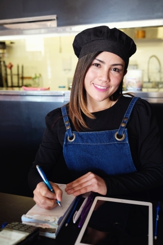 Multicultural Asian waitress taking order at Thai restaurant - Australian Stock Image