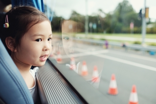 Multicultural children looking through bus window - Australian Stock Image