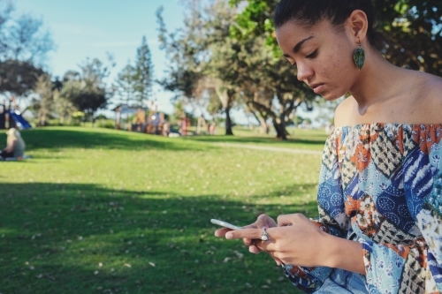 Multicultural teen girl using mobile phone - Australian Stock Image