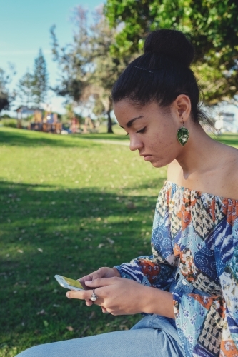 Multicultural teen girl using mobile phone - Australian Stock Image