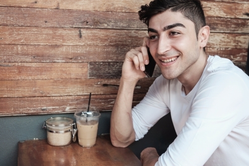 multicultural young adult man on the phone - Australian Stock Image