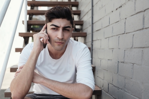 multicultural young adult man on the phone - Australian Stock Image