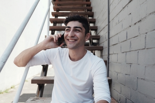multicultural young adult man on the phone - Australian Stock Image
