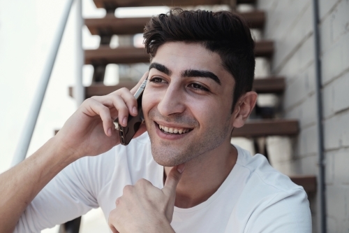multicultural young adult man on the phone - Australian Stock Image