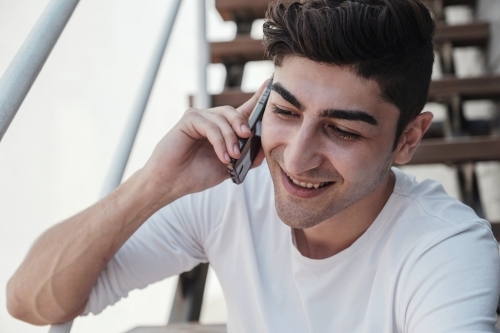 multicultural young adult man on the phone - Australian Stock Image