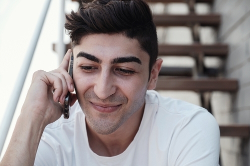 multicultural young adult man on the phone - Australian Stock Image