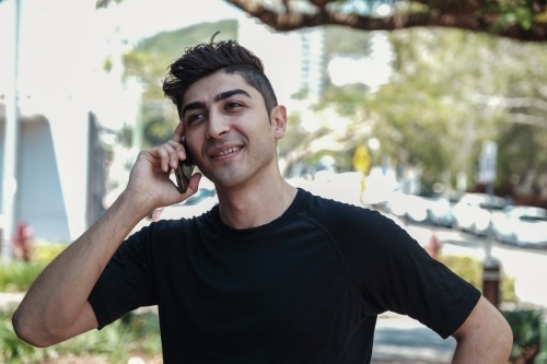 multicultural young adult man on the phone - Australian Stock Image