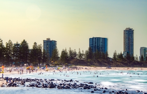 Multiple people at the beach on a hot and hazy summer afternoon.