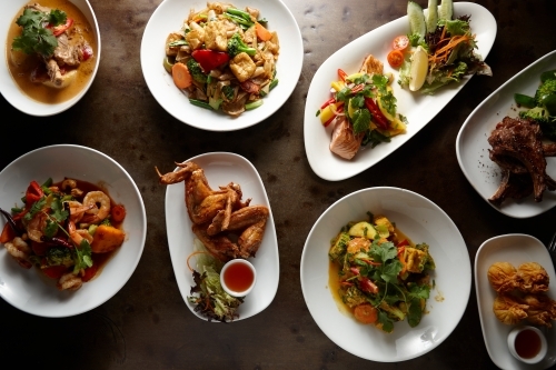 Multiple Thai food dishes on table - Australian Stock Image