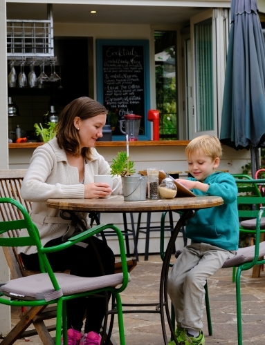 Mum and son looking at a menu in a cafe restaurant - Australian Stock Image