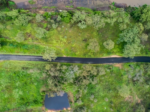 Narrow road going through green paddocks - Australian Stock Image