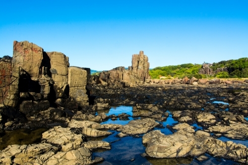 Natural rock formations with blue sky reflecting off the puddles - Australian Stock Image