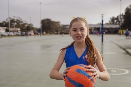 Netball girl holding ball pre game - Australian Stock Image
