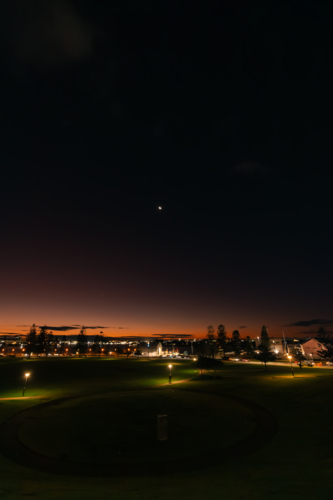 Night sky over Newcastle city with vibrant moon - Australian Stock Image