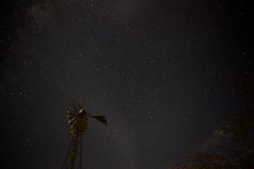 Night sky with stars and a windmill in the foreground - Australian Stock Image