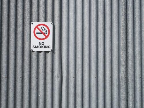 "NO SMOKING" sign on a corrugated iron wall - Australian Stock Image