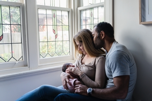 Mother and father getting newborn cuddles - Australian Stock Image