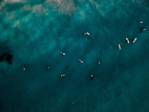 Top down view of many surfers waiting for a wave on flat clear water at North Beach , WA - Australian Stock Image