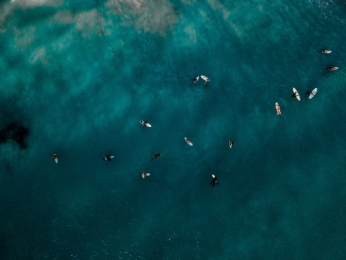 Top down view of many surfers waiting for a wave on flat clear water at North Beach , WA