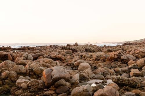 Ocean and rock view of rugged coastline at sunset - Australian Stock Image