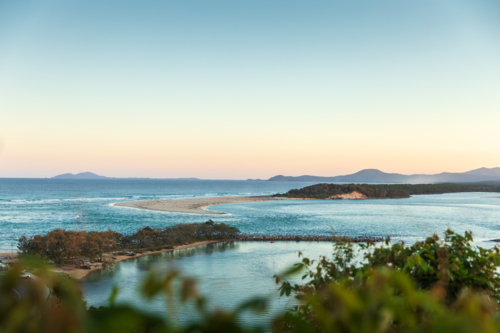Ocean view of coastal inlet and sandbar at sunset - Australian Stock Image