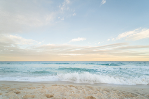 Ocean waves rolling toward shore beneath soft cloudy sky, Scarborough Beach, Perth - Australian Stock Image