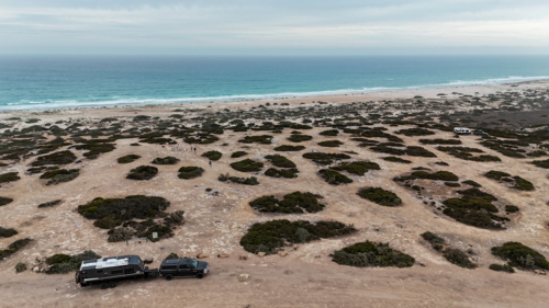 Off-road camper trailer overlooking remote coastal wilderness and ocean - Australian Stock Image