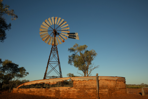 Old abandoned windmill and water storage tank - Australian Stock Image