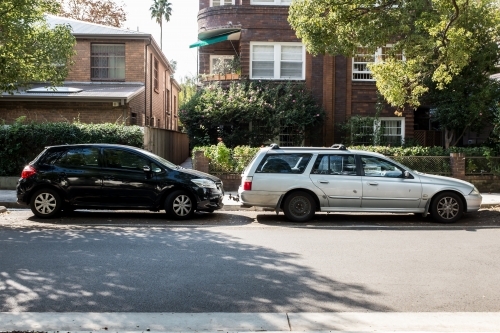 old and new car parked in a suburban street - Australian Stock Image