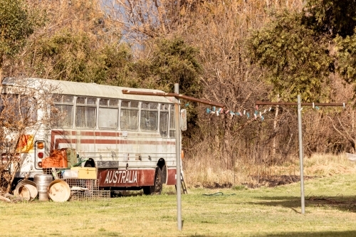 Old bus with Australia written on the side in rural backyard - Australian Stock Image