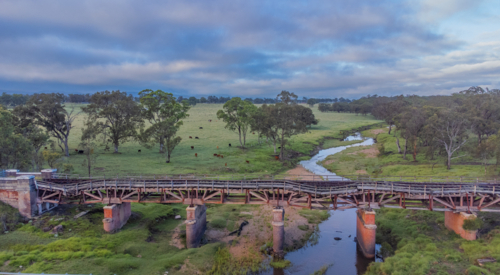 Old country railway bridge over a creek - Australian Stock Image