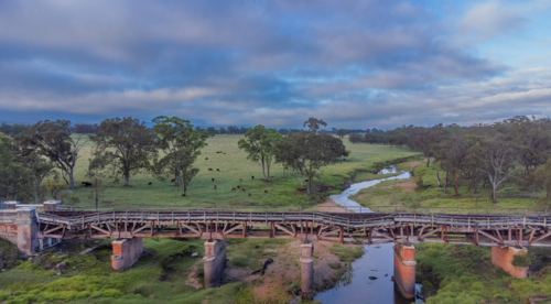Old country railway bridge over a creek - Australian Stock Image