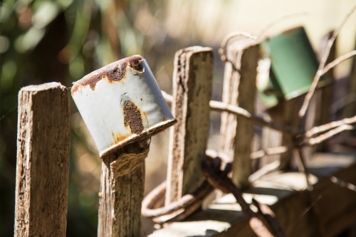 Old enamel tin cups on wooden fence pickets - Australian Stock Image