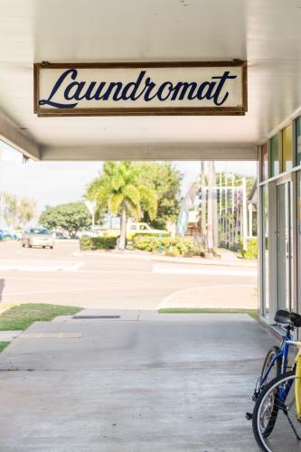 Old fashioned laundromat sign and empty footpath