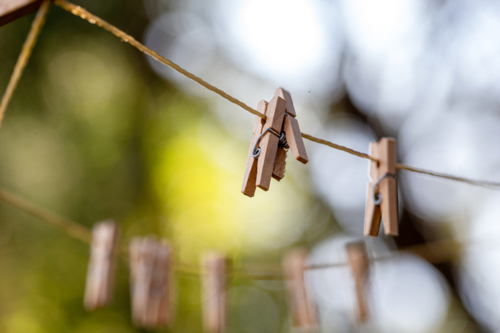 Old fashioned string clothes line with wooden pegs - Australian Stock Image