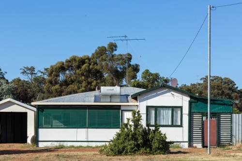 Old fibre house in front of trees