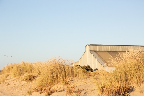 old industrial building at the port obscured in sand dunes - Australian Stock Image