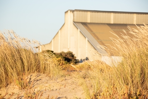 old industrial building at the port obscured in sand dunes - Australian Stock Image