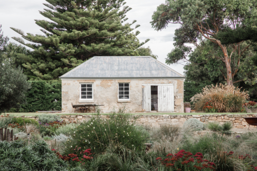 Old limestone cottage in gardens - Australian Stock Image