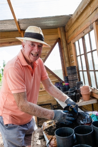 Old man potting a plant - Australian Stock Image