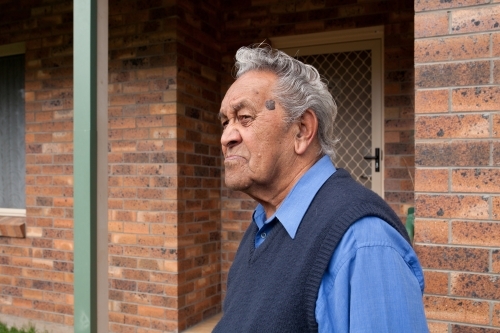 Old man standing outside his home - Australian Stock Image