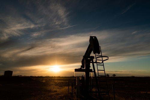 Old nodder or pumpjack from the gas fields silhouetted in the sunset - Australian Stock Image